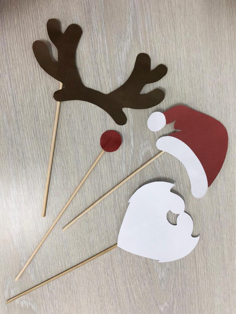 Acess&oacute;rios de festa com chifres de rena, um nariz vermelho, um chap&eacute;u de Natal e uma barba de Papai Noel em palitos de madeira.