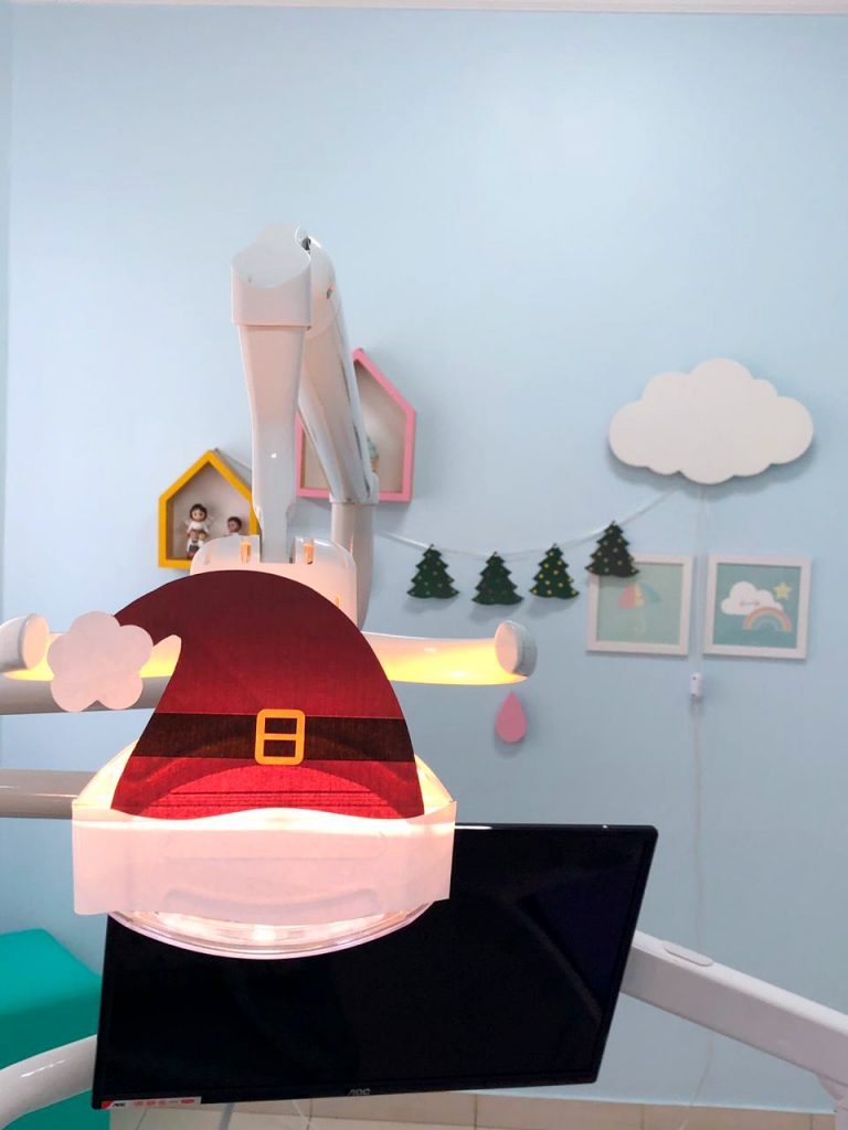 gorro de papai noel feito de papel para decorar o refletor da cadeira odontol&oacute;gica