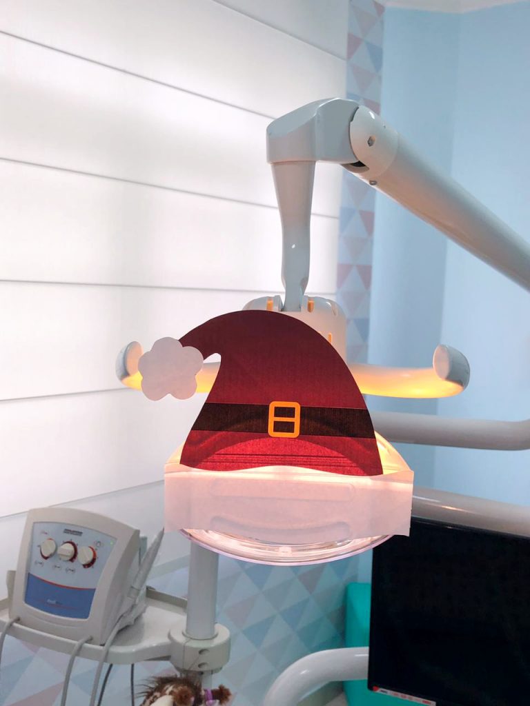 gorro de papai noel feito de papel para decorar o refletor da cadeira odontol&oacute;gica