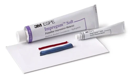 Tubo de cera 3M ESPE Impregum Soft para moldagem odontológica, com elementos aplicadores de cor vermelha e azul, preparado para uso em procedimentos odontológicos.