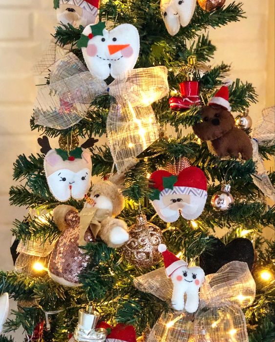 &Aacute;rvore de Natal decorada com enfeites em formato de dentes e personagens natalinos.