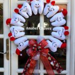 Guirlanda de Natal feita com dentes de pelúcia brancos e detalhes em vermelho, com laço decorativo.