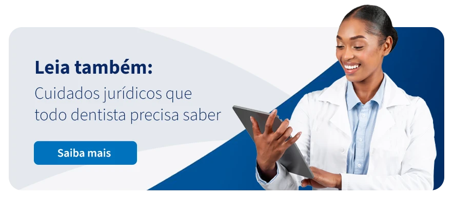 Profissional da saúde sorri enquanto lê sobre cuidados jurídicos importantes para dentistas, promovendo informações necessárias para a prática odontológica.