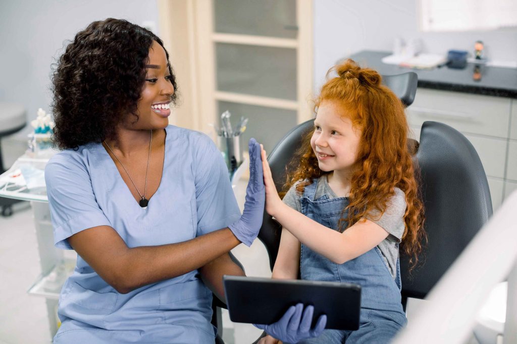 Dentista aplicando as técnicas de manejo na Odontopediatria