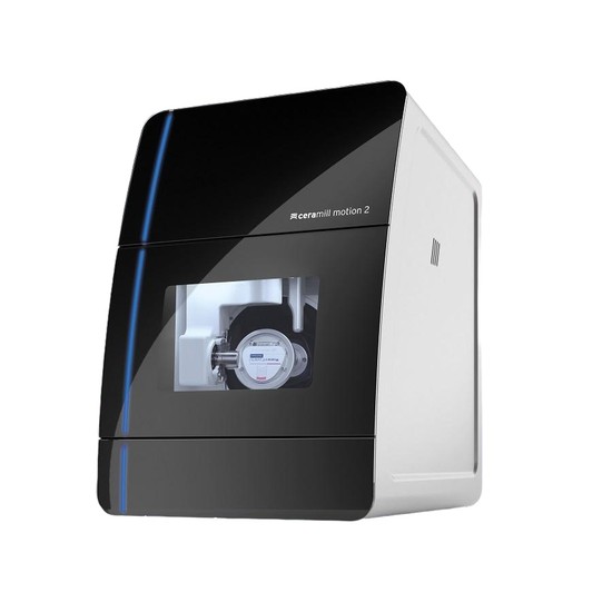 Imagem de uma fresadora Ceramill Motion 2 com acabamento preto e branco, mostrando a área interna de impressão com o componente mecânico e marca Ceramill Motion 2 na carenagem.